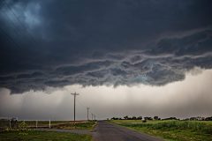 Dramatic dark storm clouds and a massive shelf cloud sweeping across the rural landscape near Elk City, Oklahoma, during the severe weather outbreak of April 14, 2026. Extreme weather photography by storm chaser Mauro Greco