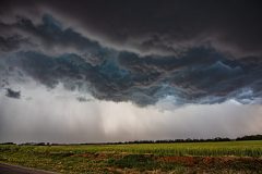 Dramatic dark storm clouds and a massive shelf cloud sweeping across the rural landscape near Elk City, Oklahoma, during the severe weather outbreak of April 14, 2026. Extreme weather photography by storm chaser Mauro Greco