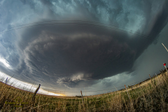 A massive, highly structured supercell thunderstorm dominates the sky over the rural plains near Brantford, Kansas, during the severe weather event of April 9, 2026. Extreme weather photography by storm chaser Mauro Greco
