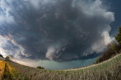A massive, highly structured supercell thunderstorm dominates the sky over the rural plains near Brantford, Kansas, during the severe weather event of April 9, 2026. Extreme weather photography by storm chaser Mauro Greco